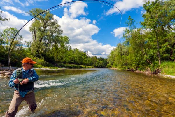 A fisherman fly fishing in a beautiful river