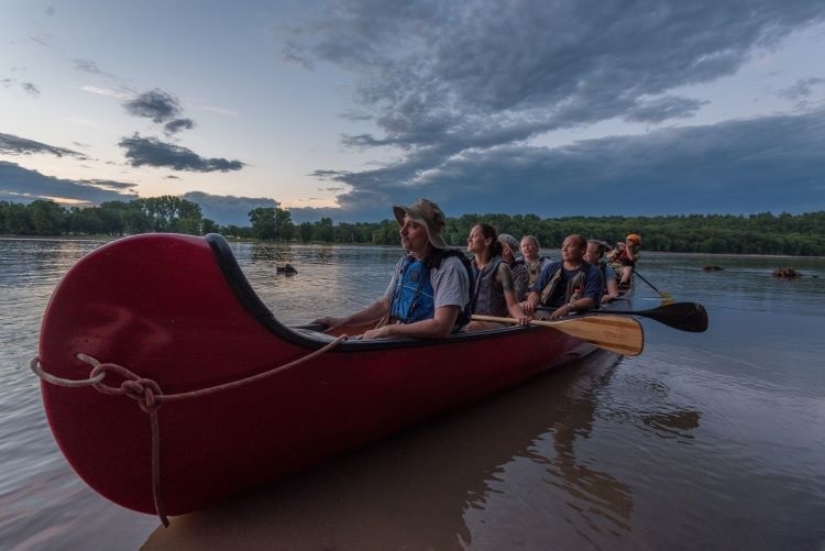 Paddling in a voyageur canoe on the Mississippi
