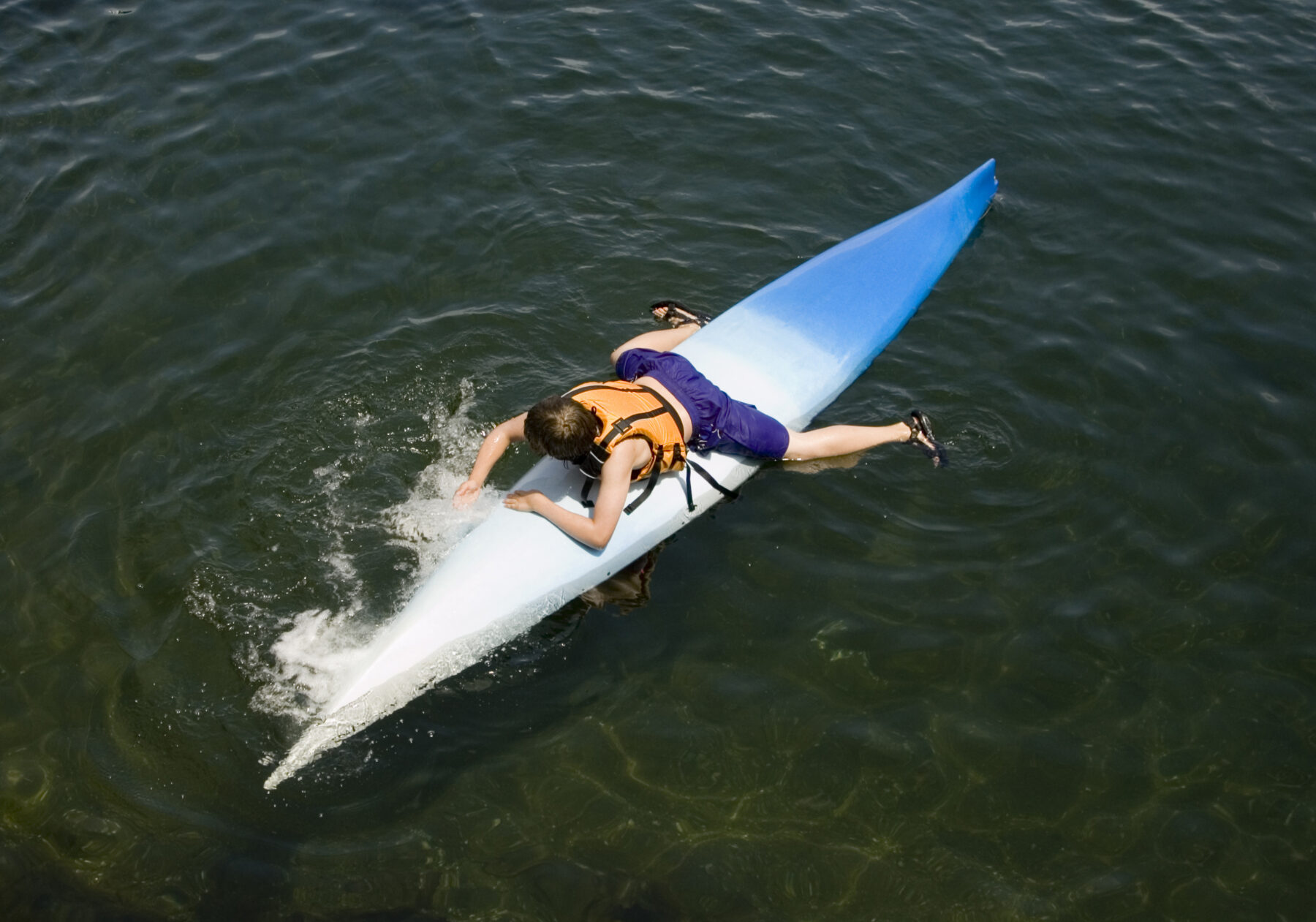 Boy on upturned kayak